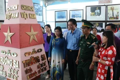 Các đại biểu tham quan một cuộc Triển lãm bản đồ và trưng bày tư liệu Hoàng Sa, Trường Sa của Việt Nam - Những bằng chứng lịch sử và pháp lý. (Ảnh: Nhật Bình/TTXVN)