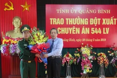 Bí thư Tỉnh ủy Quảng Bình Hoàng Đăng Quang tặng hoa cho Đại diện Bộ chỉ huy Bộ đội biên phòng Quảng Bình sau chuyên án 544LV thành công. (Ảnh: Đức Thọ/TTXVN) 