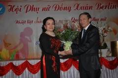 Tham tán Nguyễn Thiện Bình, Đại sứ quán Việt Nam tại Đức, tặng hoa bà Phạm Thị Tuấn, Chủ tịch hội phụ nữ Đồng Xuân ở Berlin. (Ảnh: Thanh Hải/Vietnam+)