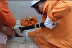 Lực lượng cứu hộ đang cố tháo dỡ bồn cầu. (Nguồn: QQ)