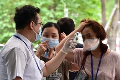 Kiểm tra thân nhiệt cho người dân Hàn Quốc để phòng tránh lây nhiễm MERS tại Trung tâm Y tế Samsung ở Seoul ngày 20/7. (Nguồn: AFP/TTXVN)