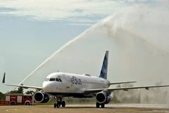 Máy bay JetBlue nhận “cầu vồng nước,” nghi lễ truyền thống chào đón các chuyến bay khai trương. (Ảnh: Vũ Lê Hà/ttXVN)