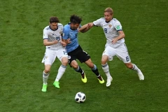 Pha tranh bóng giữa cầu thủ Rodrigo Bentancur (giữa) đội Uruguay và các cầu thủ Yuri Gazinskiy (phải) và Aleksey Miranchuk (trái) đội Nga . (Nguồn: AFP/TTXVN)