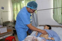 Bác sỹ thăm khám cho các bệnh nhân trong vụ ngộ độc thực phẩm. (Ảnh: Thanh Thương/TTXVN)