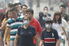 Người dân Singapore đeo khẩu trang để đối phó với tình trạng ô nhiễm khói bụi. (Nguồn: Reuters/TTXVN)