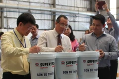 Ông Huỳnh Văn Tý, Thứ trưởng Bộ Lao động Thương binh-Xã hội, ký tên trên sản phẩm đầu tiên của chiến dịch này. (Ảnh: Hà Huy Hiệp/Vietnam+)