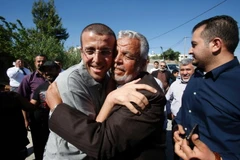 Phóng viên Mohammed al-Qiq (trái) vui mừng gặp lại người thân tại làng Dura - quê hương của anh, ở phía nam Bờ Tây sau khi được Israel trả tự do. (Nguồn: AFP/TTXVN)