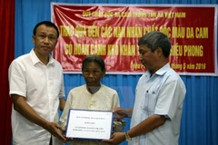 Ông Nguyễn Thế Sơn, Giám đốc Quỹ Vì nỗi đau da cam TTXVN cùng nhà tài trợ tặng nhà tình nghĩa cho bà Nguyễn Thị Viên, xã Triệu Trung, huyện Triệu Phong. (Ảnh: Trần Tĩnh/TTXVN)