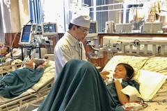 Bác sỹ chuyên khoa 2, Phạm Ngọc Kiếu, Trưởng khoa Hồi sức Tích cực, Bệnh viện Đa khoa Trung tâm An Giang thăm khám cho bệnh nhân Nguyễn Hồng Kim C. (Ảnh: Thanh Sang/ TTXVN) 