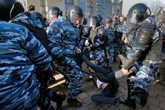 Cảnh sát chống bạo động Nga bắt giữ một người biểu tình trái phép ở Moskva ngày 26/3. (Nguồn: EPA/TTXVN)