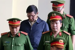 Lực lượng chức năng dẫn giải bị cáo Phan Văn Vĩnh vào tòa. (Ảnh: Trung Kiên/TTXVN) 