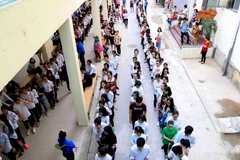 Thí sinh xếp hàng vào phòng thi đánh giá năng lực môn Ngoại ngữ trên máy tính tại Đại học Quốc gia Hà Nội, sáng 5/5. (Ảnh: Quý Trung/TTXVN)