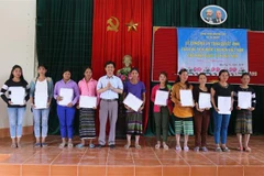 Đại diện cơ quan chức năng tỉnh Quảng Trị trao Quyết định nhập Quốc tịch Việt Nam cho người dân. (Ảnh: Nguyên Lý/TTXVN) 