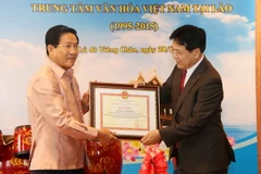 Thứ trưởng Bộ Văn hóa - Thông tin và Du lịch Việt Nam Vương Duy Biên (trái) trao Bằng khen cho các cá nhân và tập thể có công đóng góp cho sự phát triển của Trung tâm Văn hóa Việt Nam tại Lào trong suốt 20 năm qua. (Ảnh: Phạm Kiên​/TTXVN)