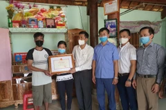 Lãnh đạo Sở Giáo dục và Đào tạo Nghệ An trao bằng khen của Bộ Giáo dục và Đào tạo cho gia đình em Tuấn. (Ảnh: Bộ Giáo dục và Đào tạo)