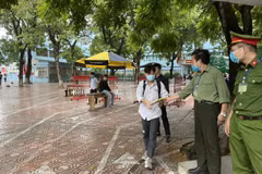 Thí sinh Hà Nội kết thúc buổi thi môn tổ hợp, được phát áo mưa khi rời trường thi. (Ảnh: PV)
