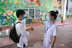 Thí sinh Hà Nội được đo thân nhiệt trước khi vào điểm thi. (Ảnh: Minh Sơn/Vietnam+)