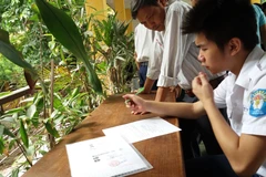 Thí sinh làm hồ sơ xét tuyển đại học. (Ảnh: Phạm Mai/Vietnam+)