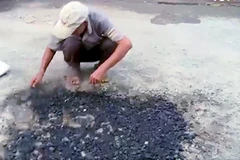 Hình ảnh chụp từ clip ghi lại hình ảnh ông Cao Văn Long vá "ổ gà" trên đường ở thành phố Long Xuyên.