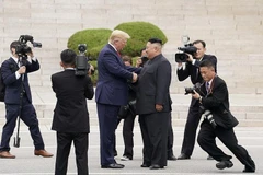 Tổng thống Mỹ Donald Trump cùng với nhà lãnh đạo Triều Tiên Kim Jong-un bắt tay nhau khi đứng trên phần lãnh thổ Triều Tiên ở làng đình chiến Panmunjom trong Khu phi quân sự. (Nguồn: Reuters)