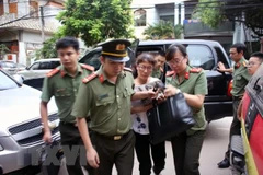 Cơ quan an ninh đưa bà Nguyễn Thị Hồng Nga, chuyên viên phòng Khảo thí và Quản lý chất lượng, Sở Giáo dục và Đào tạo tỉnh Sơn La, thư ký Ban chỉ đạo, ủy viên tổ chấm thi trắc nghiệm về nhà riêng để kiểm tra, khám xét. (Ảnh: Hữu Quyết/TTXVN)