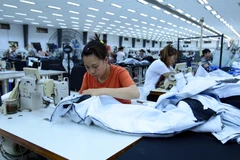 Công nhân sản xuất hàng may mặc tại Công ty trách nhiệm hữu hạn Kydo Việt Nam. (Ảnh: Phạm Kiên/TTXVN)