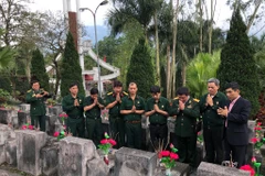 Hội Cựu Chiến binh TTXVN thắp hương tưởng niệm các anh hùng liệt sỹ tại Nghĩa trang Quốc gia Vị Xuyên. (Ảnh: PV/Vietnam+)