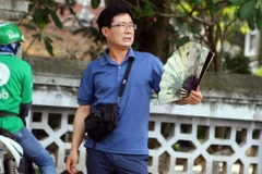 Một khách nước ngoài khó chịu với thời tiết nắng nóng tại Thủ đô Hà Nội. (Ảnh: Danh Lam/TTXVN)