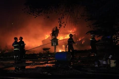 Cảnh sát phòng cháy chữa cháy Công an thị xã Thuận An đang tích cực dập lửa. (Ảnh: Nguyễn Văn Việt/TTXVN)