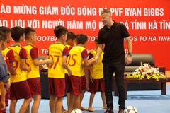 Huyền thoại Manchester United bắt tay với các cầu thủ nhí của câu lạc bộ bóng đá học đường huyện Thạch Hà, Hà Tĩnh. (Ảnh: Phan Quân/TTXVN)