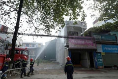 Lực lượng chữa cháy nỗ lực dập tắt đám cháy. (Ảnh: Phan Tuấn Anh/TTXVN)