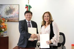 Phó Tổng giám đốc Đinh Đăng Quang và Tổng giám đốc của Notimex Sanjuana Martínez Montemayor trao đổi văn bản ký kết. (Ảnh: Việt Hùng/Vietnam+)