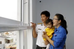 Niềm vui của một gia đình trẻ trong ngày nhận bàn giao nhà ở xã hội. (Ảnh: Hoàng Hải/TTXVN)