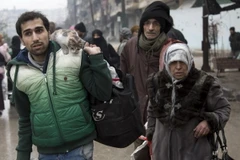 Người dân Syria sơ tán khỏi các khu vực do quân nổi dậy kiểm soát để đến các khu vực đã được quân Chính phủ giải phóng ở Aleppo. (Nguồn: AFP/TTXVN)