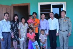 Đoàn thăm hỏi gia đình và tặng quà cháu bé bị xâm hại. (Ảnh: Phan Minh Hưng/TTXVN)