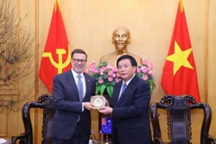 Giám đốc Học viện Chính trị quốc gia Hồ Chí Minh Nguyễn Xuân Thắng tặng quà lưu niệm cho Đại sứ Australia tại Việt Nam Andrew Goledzinowski. (Ảnh: Văn Điệp/TTXVN)