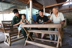 Ông Nguyễn Bá Cường (áo trắng, bìa phải), là một trong những người đầu tiên được di dân theo Đề án 407 đã có cuộc sống ổn định qua 3 thế hệ. (Ảnh: Thanh Tân/TTXVN)