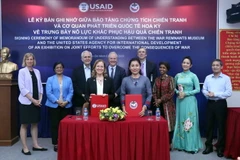 Bà Aler Grubbs, Giám đốc Quốc gia USAID tại Việt Nam và bà Trần Xuân Thảo, Giám đốc Bảo tàng Chứng tích Chiến tranh ký thỏa thuận hợp tác về trưng bày nỗ lực khắc phục hậu quả chiến tranh. (Ảnh: Xuân Khu/TTXVN)