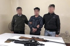 Đối tượng Tráng A Lầu (đứng giữa, còng tay) bị bắt giữ. (Ảnh: TTXVN phát)