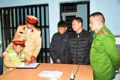 Trung tá Lê Anh Sơn, Đội trưởng Đội Cảnh sát giao thông số 2, Công an thành phố Hải Phòng (áo vàng, đứng) chỉ đạo công tác. (Ảnh: TTXVN phát)