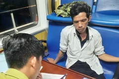 Cơ quan chức năng lập biên bản đối tượng Phạm Thanh Tân. (Ảnh TTXVN phát)