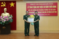 Đại tướng Phan Văn Giang, Ủy viên Bộ Chính trị, Phó Bí thư Quân Ủy Trung ương, Bộ trưởng Bộ Quốc phòng trao Huy hiệu 40 năm tuổi Đảng tặng Thượng tướng Vũ Hải Sản. (Ảnh: Hồng Pha/TTXVN/phát)