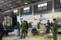 Lực lượng Công an khám xét Trung tâm đăng kiểm xe cơ giới 29-10D. (Ảnh: TTXVN phát)