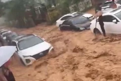 Hình ảnh các phương tiện bị mắc kẹt trong dòng nước bùn đất đỏ khu vực cạnh hồ Đồng Đò, Sóc Sơn. (Ảnh: Vietnam+)