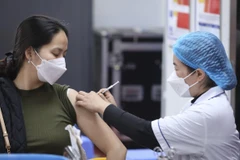 Nhân viên y tế tiêm vaccine phòng COVID-19 cho người dân. (Ảnh: Minh Quyết/TTXVN)