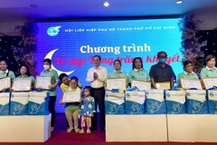 Phó Bí thư Thành ủy Thành phố Hồ Chí Minh Nguyễn Văn Hiếu tặng bằng khen biểu dương phụ nữ khuyết tật tiêu biểu. (Ảnh: Thu Hương/TTXVN