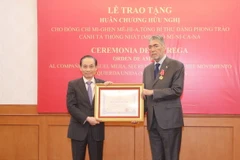 Ông Lê Hoài Trung, Ủy viên Trung ương Đảng, Trưởng Ban Đối ngoại Trung ương trao Huân chương Hữu nghị của Chủ tịch nước cho ông Miguel Mejia, Tổng Bí thư Đảng Phong trào cánh tả thống nhất Dominica. (Ảnh: Phương Hoa/TTXVN)