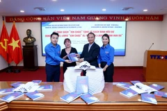 Ông Lê Duy Truyền, nguyên Phó Tổng Giám đốc TTXVN, Phó Chủ tịch Hội Hữu nghị Việt Nam-Venezuela và Tham tán Đại sứ quán Venezuela tại Việt Nam Cora Fernandez trao tặng cuốn sách "Xin chào" cho Đoàn thanh niên TTXVN. (Ảnh: Phạm Kiên/TTXVN)