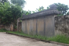 Tấm bia (đang được tận dụng làm tường rào) được ghép lại từ 6 phiến đá xanh, ghi lại công các tướng sỹ thời Hậu Lê và những người đã soạn, khắc, dựng nên văn bia này. (Ảnh: Hoa Mai/TTXVN)