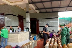 Lực lượng chức năng kiểm tra, thu giữ dầu DO không rõ nguồn gốc. (Ảnh: TTXVN phát)